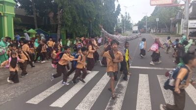 Personel Polsek Suela Atur Lalu Lintas di Depan SDN 02 Suela, Bantu Pelajar Menyeberang
